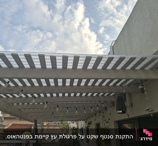 פרגולה מעץ עם תאורה תלויה על מרפסת